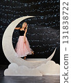A beautiful blonde woman in a black top and a voluminous pink tulle skirt poses in a large glitter 131838722