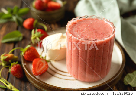 Fresh strawberry protein smoothie on a wooden table with fresh strawberries and a protein powder. 131839029