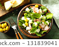 Fresh arugula salad with prosciutto, melon, and olives for a delicious summer meal. 131839041