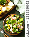 Fresh arugula salad with prosciutto, melon, and olives for a delicious summer meal. 131839042