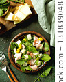 Fresh arugula salad with prosciutto, melon, and olives for a delicious summer meal. Top view flat lay 131839048