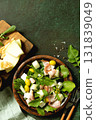 Fresh arugula salad with prosciutto, melon, and olives for a delicious summer meal. Top view flat lay background. 131839049
