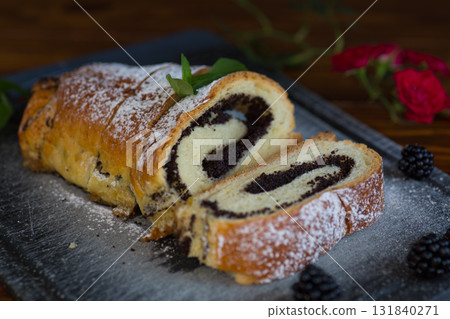 Homemade poppy seed roll with powdered sugar on a tray 131840271
