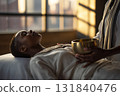 A person experiences sound therapy with a brass bowl in a peaceful environment, promoting relaxation and mindfulness. The tranquil indoor setting enhances the calming experience 131840476
