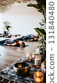 Participants engage in a sound therapy session, lying on mats in a serene wellness space adorned with plants and soft lighting, creating a peaceful atmosphere for relaxation and healing 131840480