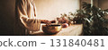 A person holds a sound therapy bowl in a serene space filled with candles and dried flowers. This setting promotes relaxation and mindfulness during the therapy session, banner 131840481