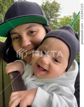 Mother and Baby Smiling in Matching Caps Mother and Baby Smiling in Matching Caps 131841123