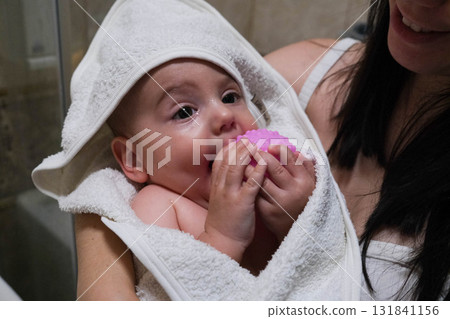 Baby Wrapped in Towel Holding Pink Toy Baby Wrapped in Towel Holding Pink Toy 131841156
