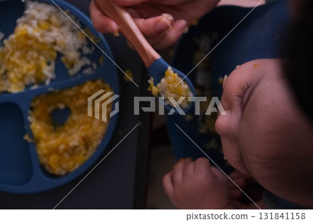Baby Eating Rice and Eggs with Spoon Baby Eating Rice and Eggs with Spoon 131841158