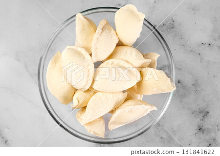 bowl of frozen dumplings on light background. Frozen semi finished dough products bowl of frozen dumplings on light background. Frozen semi finished dough products 131841622