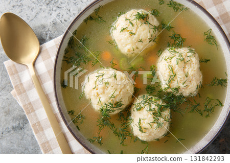 Jewish matzah balls soup with chicken broth, vegetables and dill close-up in a plate. Horizontal top view Jewish matzah balls soup with chicken broth, vegetables and dill close-up in a plate. Horizontal top view 131842293