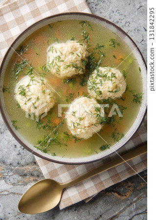 Healthy Jewish Matzo Ball Soup with Dill and Broth closeup on the plate. Vertical top view Healthy Jewish Matzo Ball Soup with Dill and Broth closeup on the plate. Vertical top view 131842295