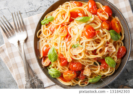 Tasty Margherita pasta with fresh tomatoes, basil, mozzarella, and garlic closeup on the plate. horizontal top view 131842303