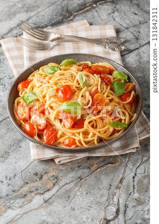 Pasta Margherita with fresh tomatoes, mozzarella cheese, basil and olive oil close-up in a plate. Vertical 131842311