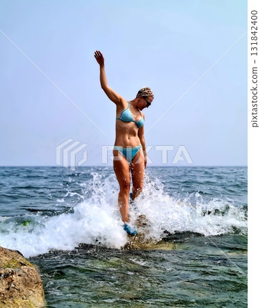 Woman Standing On Rock Splashed By Baikal Waves 131842400