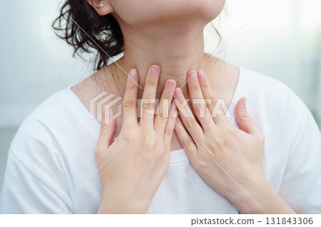 Asian woman touching her neck and throat for thyroid gland problem. Asian woman touching her neck and throat for thyroid gland problem. 131843306