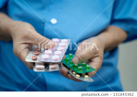 Asian elderly woman holding pill drug in hand, strong healthy medical concept. 131843362