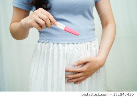Asian holding pregnancy test for female of ovulation day, fetus, maternity, childbirth, birth control. Asian holding pregnancy test for female of ovulation day, fetus, maternity, childbirth, birth control. 131843430