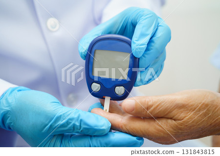 Asian doctor using digital glucose meter for check sample blood sugar level to treatment diabetes. 131843815