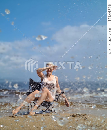 Woman enjoying refreshing summer splashes on sandy Baikal shore Woman enjoying refreshing summer splashes on sandy Baikal shore 131844246
