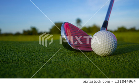 Golf clubs and balls on a green lawn in a beautiful golf course with morning sunshine. 131844964