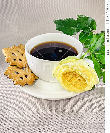 A cozy coffee break with black coffee and golden, patterned butter cookies on a textured surface A cozy coffee break with black coffee and golden, patterned butter cookies on a textured surface 131845700