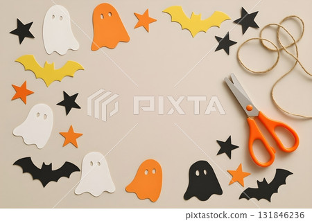 Halloween paper craft flat lay with ghost and bat cutouts, stars, orange scissors 131846236