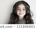 A portrait of a smiling girl with headphones, set against a contrasting black and white background, emphasizing her joyful expression and the simplicity of the design 131846801