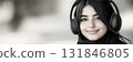 A classic and minimalistic black-and-white image of a smiling Arab girl wearing headphones, radiating purity and sophistication, ideal for clean and contemporary design concepts, banner 131846805