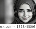 A timeless black-and-white portrait of a smiling Arab girl wearing headphones, designed in a clean and minimalistic style, perfect for a modern and elegant mock-up 131846806