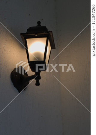Black Lantern Casts a Warm Glow on a Quiet Evening Wall Black Lantern Casts a Warm Glow on a Quiet Evening Wall 131847266