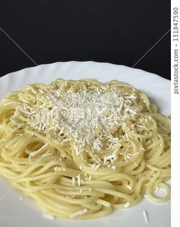 Close-up shot of spaghetti on a white plate topped with grated salted ricotta. Cooking delicious food at home. 131847590