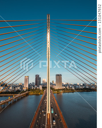 Symmetric modern cable-stayed bridge over Han River in Da Nang, Contemporary urban span connecting city skyline across Vietnamese waterway Symmetric modern cable-stayed bridge over Han River in Da Nang, Contemporary urban span connecting city skyline across Vietnamese waterway 131847652