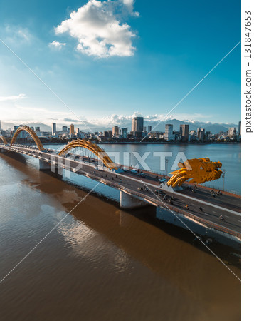 Golden Dragon Bridge over Han River in Da Nang at sunset, Iconic Vietnamese landmark spanning urban waterway with city skyline view 131847653