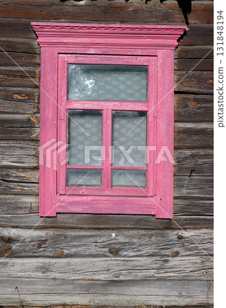 A vintage wooden window frame in an old log wall. A vintage wooden window frame in an old log wall. 131848194