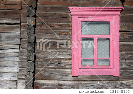 A vintage wooden window frame in an old log wall. A vintage wooden window frame in an old log wall. 131848195