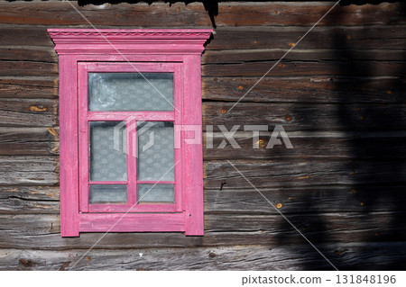 A vintage wooden window frame in an old log wall. A vintage wooden window frame in an old log wall. 131848196