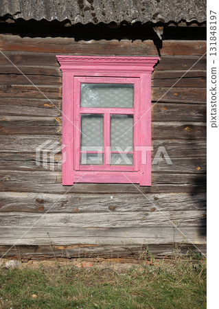 A vintage wooden window frame in an old log wall. A vintage wooden window frame in an old log wall. 131848197