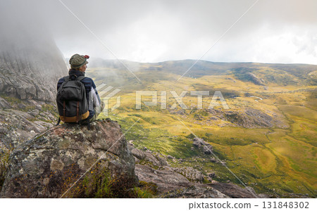 Young woman in sports clothing sitting on rocks enjoying the scenery of Andringitra national park, large stones massif background, during hike to pic Boby peak 131848302