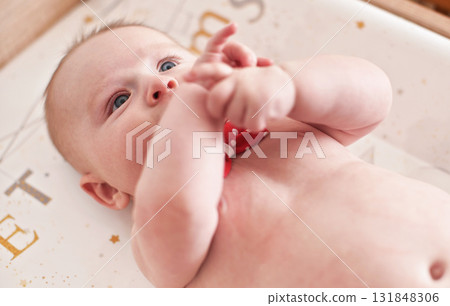 4 months old infant baby boy at changing table, detail on his head 131848306