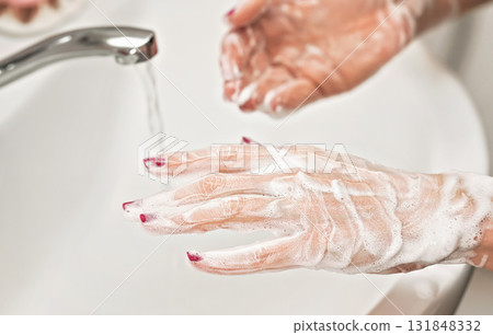 Young woman washing her hands under water tap faucet with soap. Detail on suds covered skin. Personal hygiene concept Young woman washing her hands under water tap faucet with soap. Detail on suds covered skin. Personal hygiene concept 131848332