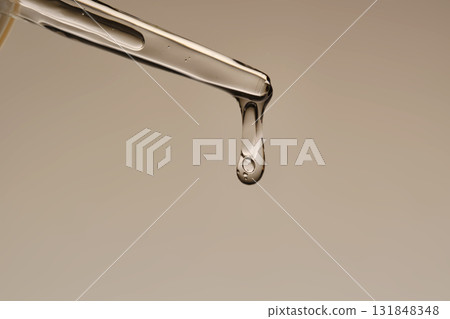 The texture of the hyaluronic serum flowing down the dropper. The texture of the hyaluronic serum flowing down the dropper. 131848348