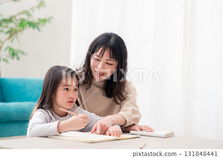 A mother studying with her kindergarten-aged daughter A mother studying with her kindergarten-aged daughter 131848441