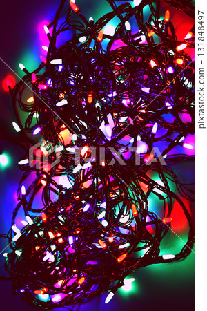 Shining Electric Garland with Intertwined Wires in Darkness. Glowing Garland Vertical Background Shining Electric Garland with Intertwined Wires in Darkness. Glowing Garland Vertical Background 131848497
