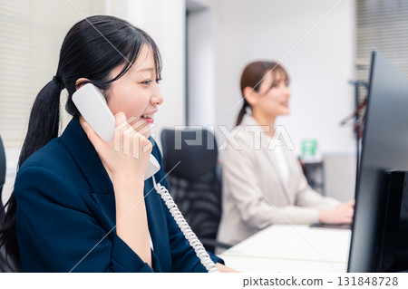 一位微笑的女商人在辦公室接電話 一位微笑的女商人在辦公室接電話 131848728