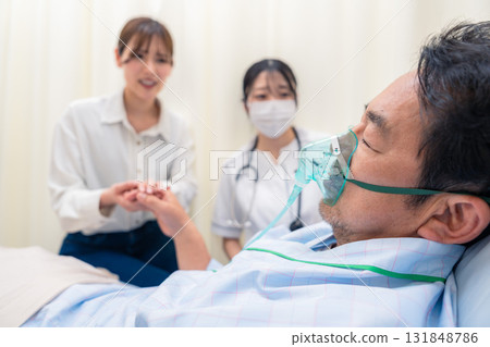 一名年輕女子探望使用呼吸器的家人 131848786