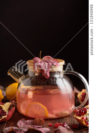 Autumn Beverage: Pomegranate Tea with Lemon and Ginger on Rustic Table 131848998