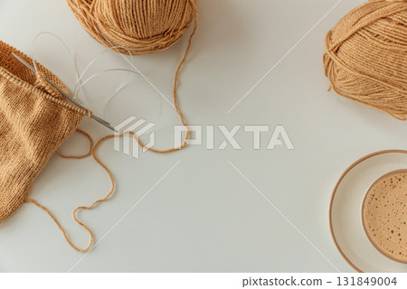Knitting Project with Cup of Cappuccino on White Table in Cozy Setting 131849004