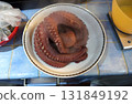 A hot, steaming octopus on a plate ready to be cut or a salad. 131849192