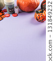 Halloween purple frame background flatlay with pumpkins and party decor 131849232